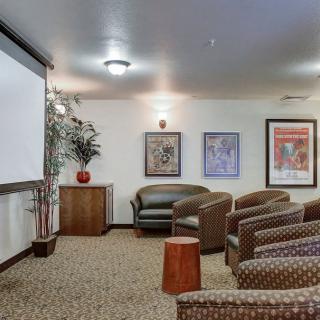 A cozy home theater room with comfortable seating and a large projector screen.