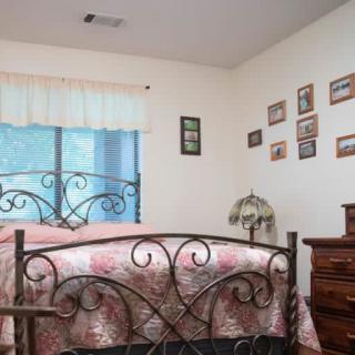 A cozy bedroom with a wrought iron bed and wall decor.