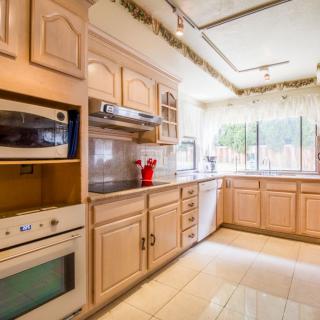 A bright kitchen with wooden cabinetry and modern appliances.