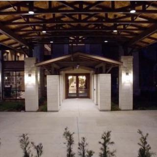 A well-lit building entrance at night with a wooden and concrete structure.