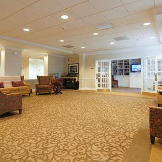 A spacious and well-lit lobby with comfortable seating and a patterned carpet.