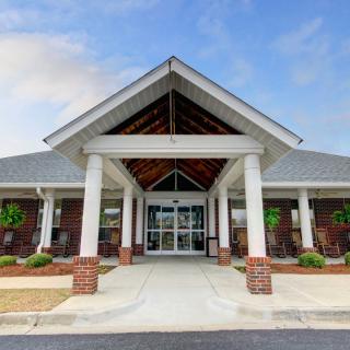 A modern building entrance with columns and brick accents under a clear sky.