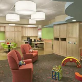 A colorful children's playroom featuring comfortable seating and a variety of toys.