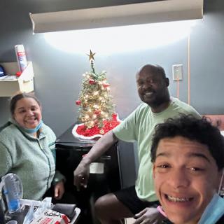 A joyful family gathering around a Christmas tree, sharing smiles and holiday spirit.