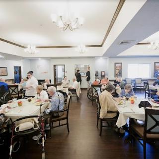 Residents enjoy a meal together in a communal dining area.