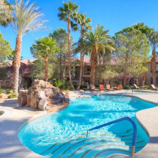 A tranquil outdoor pool area surrounded by palm trees, perfect for a sunny vacation retreat.
