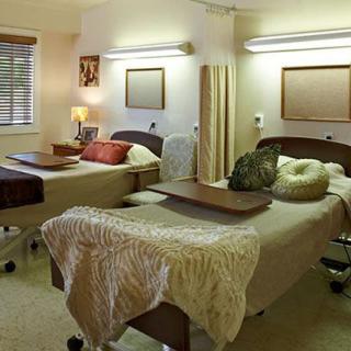 A hospital room with two beds separated by a curtain, designed for patient care.