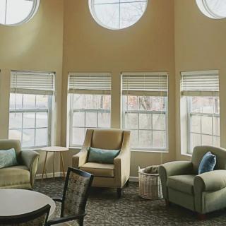 A cozy living room with large windows and comfortable armchairs.