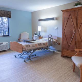 A hospital room with a patient bed and wooden furniture, designed for comfort and care.