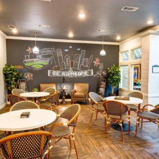 A cozy cafe interior with a chalkboard wall and comfortable seating.