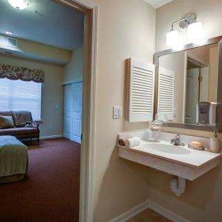 A cozy residential bathroom with a view of an adjacent bedroom.