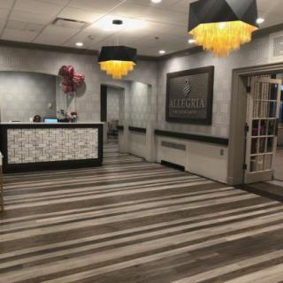 A modern hotel lobby with a stylish reception desk and contemporary chandeliers.