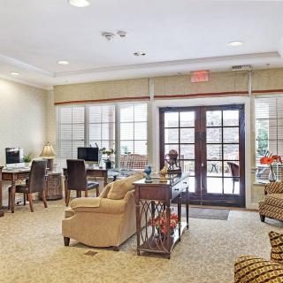 A cozy lounge area with comfortable seating, computers, and large windows.