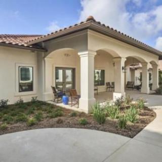 A modern residential home with a covered patio and landscaped garden.