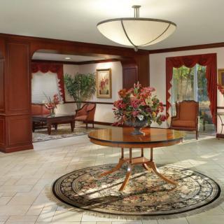 A well-appointed lobby with elegant furnishings and a central floral arrangement on a wooden table.