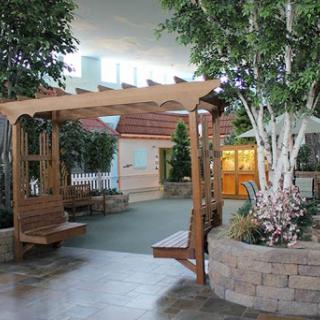 A serene indoor garden area featuring a wooden swing and lush decorative plants.