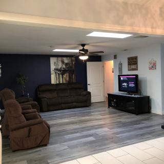 A cozy living room with modern decor, featuring brown recliner chairs and a sofa facing a television.