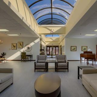 A spacious and modern living room filled with natural light, showcasing stylish furniture and an open layout.