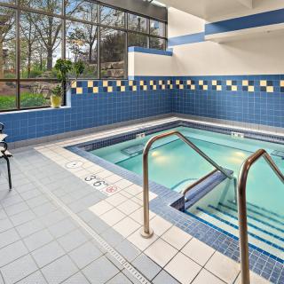 An inviting indoor hot tub area with blue tiled walls and natural lighting.