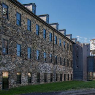 A historic stone building with multiple windows under a clear blue sky.