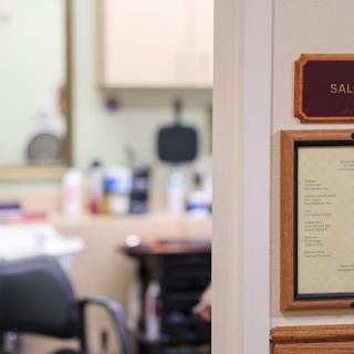 Interior view of a barbershop with a focus on the entrance signage.