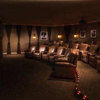 A cozy home theater with comfortable recliners and dim lighting for an immersive cinema experience.