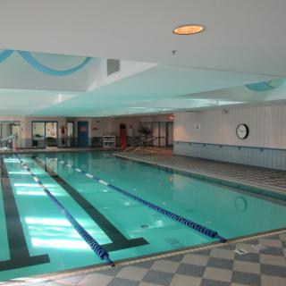 An indoor swimming pool with marked lanes and natural lighting.