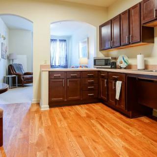 A cozy kitchen with wooden flooring and dark cabinetry.
