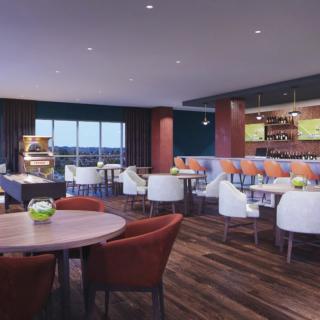 A modern restaurant interior with a dining area and bar.
