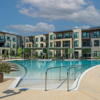 Modern apartment complex with a large outdoor swimming pool.