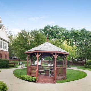 A serene garden featuring a central gazebo surrounded by lush greenery and walking paths.