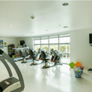 A modern fitness center featuring treadmills and stationary bikes in a well-lit indoor setting.
