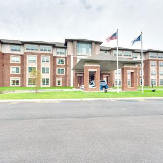 Exterior view of a hotel with flags flying near the entrance.