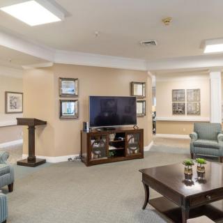 A modern living room with a TV, comfortable chairs, and a coffee table.