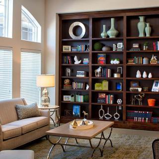 A cozy living room with a large bookshelf, comfortable sofa, and elegant coffee table.
