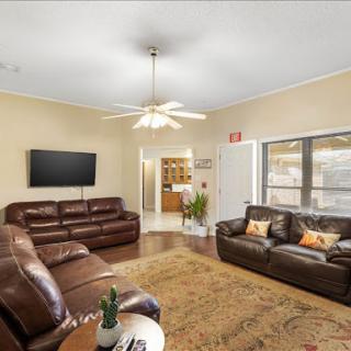 A cozy living room featuring comfortable leather sofas, a television, and a warm atmosphere.