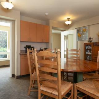 A cozy dining room with wooden furniture, adjacent to a kitchen area.