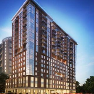 A modern high-rise apartment building illuminated at dusk.