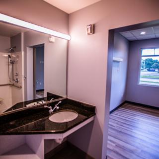 A modern bathroom interior with a sleek sink, mirror, and large window.