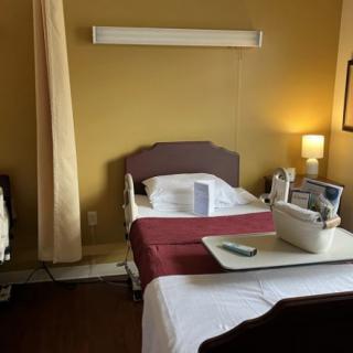 A well-lit hospital room featuring a medical bed with surrounding equipment.