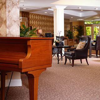 A cozy lounge area featuring a piano and comfortable seating.