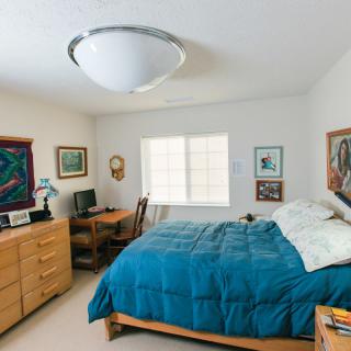 A cozy bedroom with blue bedding and wooden furniture.