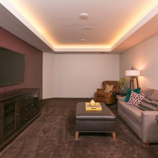A cozy, modern living room with a sofa, TV, and stylish lighting.