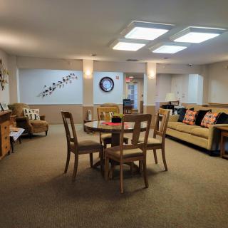 Spacious basement living area with a table, chairs, and sofa.