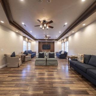 A spacious and modern living room with elegant furnishings and wooden flooring.