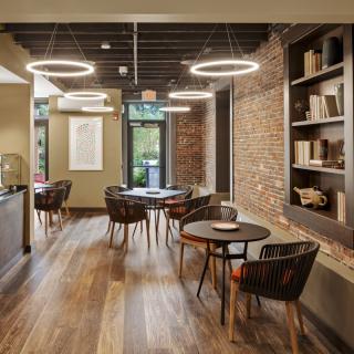 A modern cafe interior with brick walls, wooden flooring, and cozy lighting.