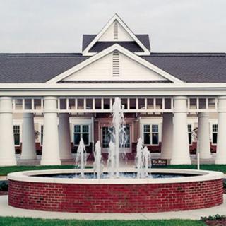A building with prominent columns and a fountain in front.