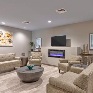 A modern living room with sleek furniture, a fireplace, and contemporary artwork.