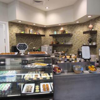 A cozy bakery interior with a display case filled with pastries and desserts.