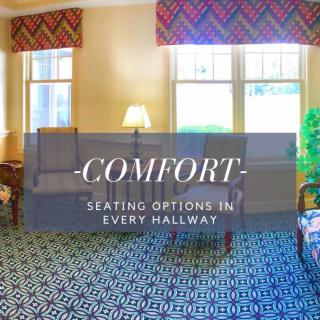 A cozy seating area in a hallway with comfortable furniture and warm lighting.